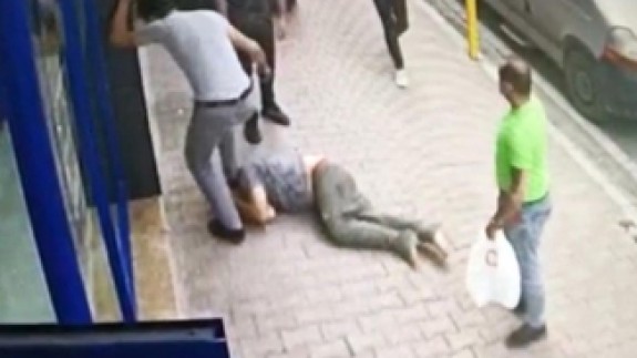 Çocuklardan para isteyen adamı,  yerde tekmeleyerek dövdüler
